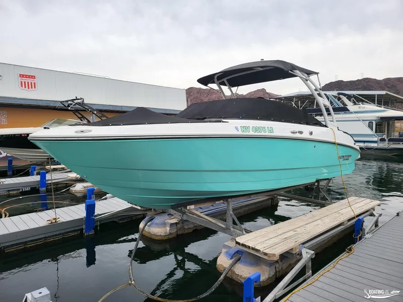 Slide: The Image of 2023 Monterey M22 boat docked, turquoise hull, covered, at marina. - 15