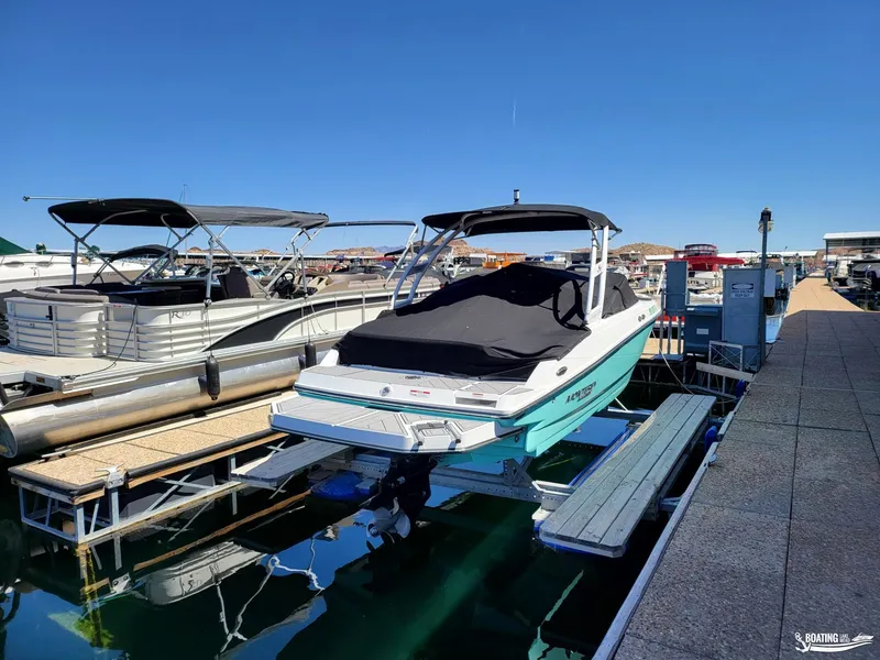 Slide: The Image of 2023 Monterey M22 boat docked at marina with cover on. - 17