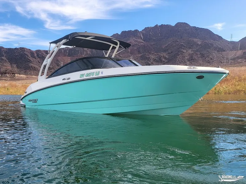 Slide: The Image of 2023 Monterey M22 boat on water with mountainous backdrop. - 2