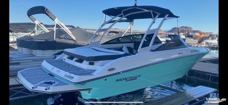 Slide: The Image of 2023 Monterey M22 boat docked at a marina with a black canopy. - 20