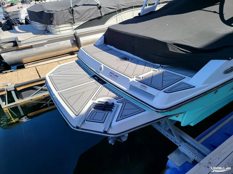 Slide: The Image of 2023 Monterey M22 boat docked, featuring a spacious swim platform and sleek design. - 21