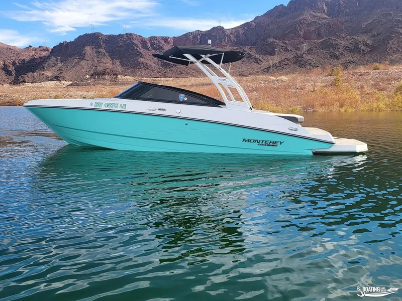 Slide: The Image of 2023 Monterey M22 boat on a serene lake with mountainous backdrop. - 3