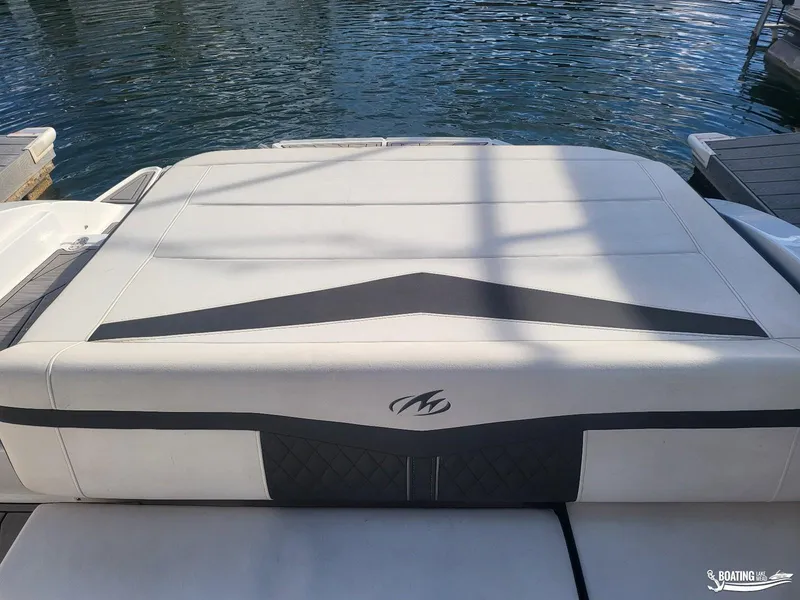 Slide: The Image of 2023 Monterey M22 boat with sleek white and black seating, docked by the water. - 31