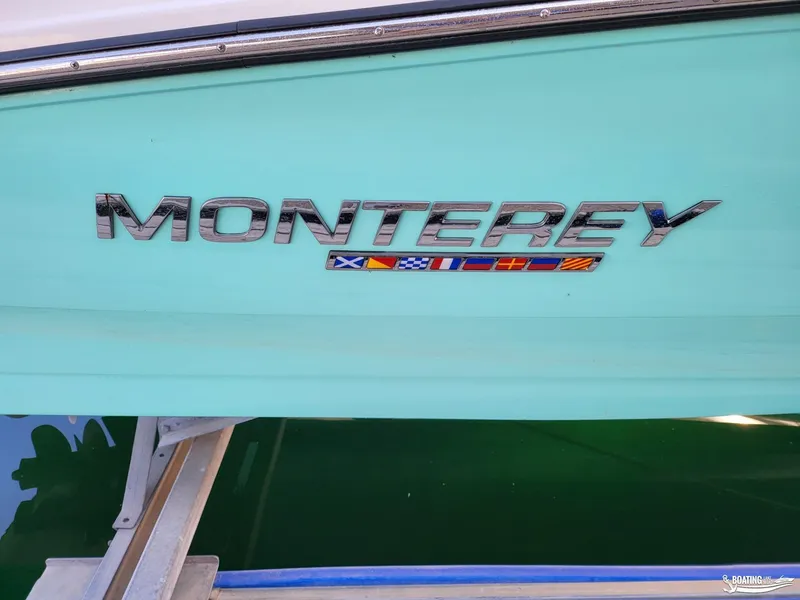 Slide: The Image of 2023 Monterey M22 boat with logo and nautical flags on turquoise hull. - 35