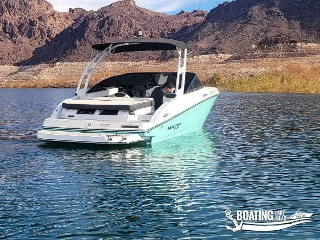 Slide: The Image of 2023 Monterey M22 boat on Lake Mead with rocky hills in the background. - 5