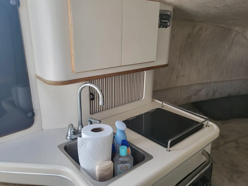 Slide: The Image of 1993 Sea Ray Laguna 29 Walkaround interior with sink, stove, and storage cabinets. - 11
