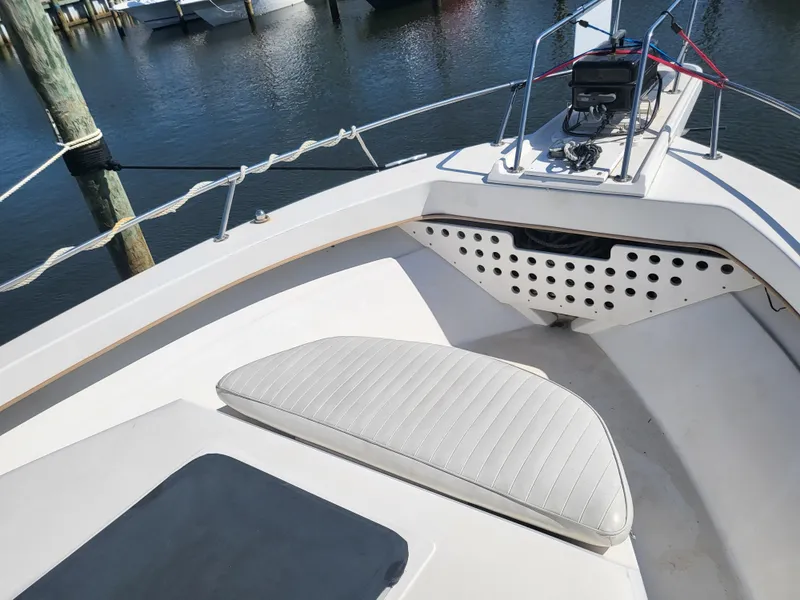 Slide: The Image of 1993 Sea Ray Laguna 29 Walkaround boat deck with seating and railing, docked by the water. - 24