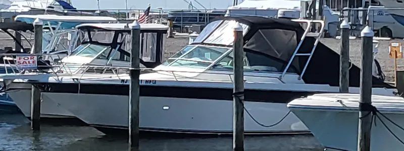 Slide: The Image of 1993 Sea Ray Laguna 29 Walkaround boat docked at marina, partially covered, with "For Sale" sign. - 26
