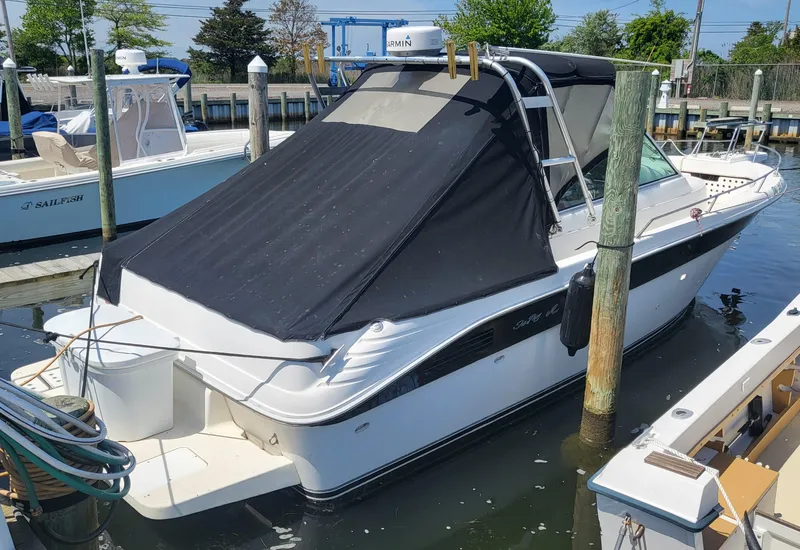 Slide: The Image of 1993 Sea Ray Laguna 29 Walkaround boat docked with black canopy cover. - 27