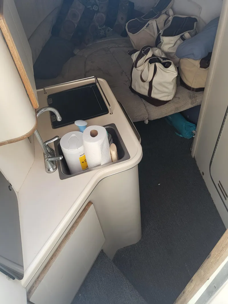 Slide: The Image of 1993 Sea Ray Laguna 29 Walkaround cabin interior with sink and storage. - 3