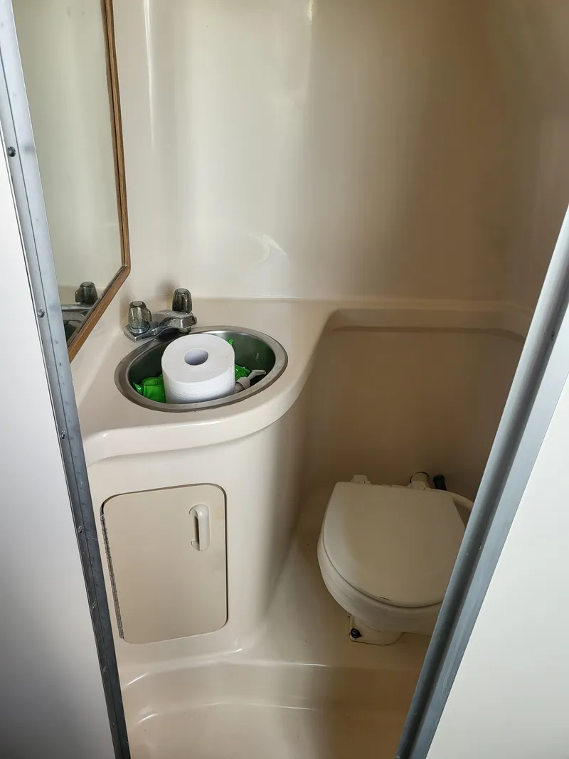 Slide: The Image of Compact bathroom in 1993 Sea Ray Laguna 29 Walkaround boat with sink and toilet. - 8