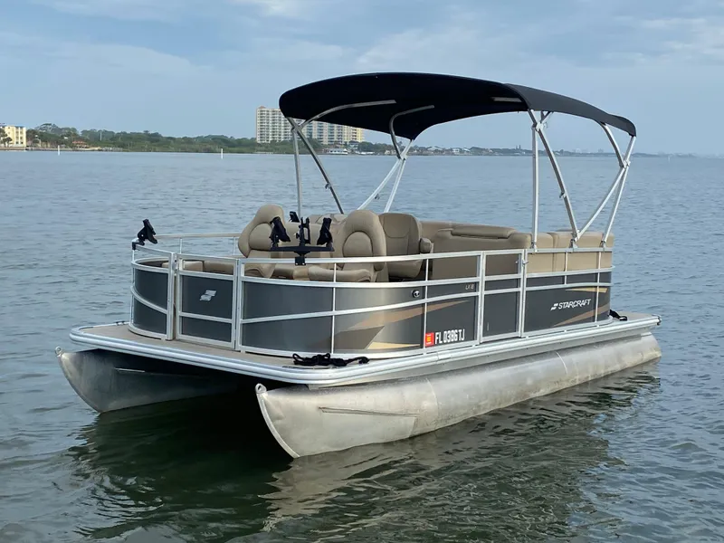 Slide: The Image of 2022 Starcraft LX 18 F pontoon boat on calm water. - 2