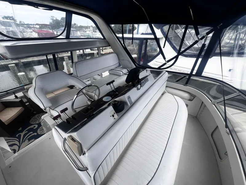 Slide: The Image of Interior of 1993 Carver 350 Aft Cabin yacht with white seating and helm station. - 11