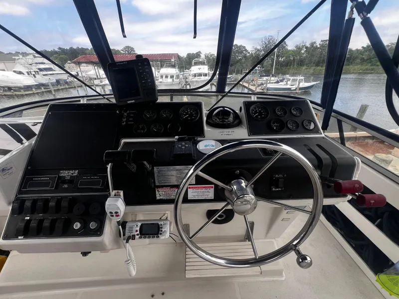 Slide: The Image of 1993 Carver 350 Aft Cabin helm with steering wheel, gauges, and navigation equipment. - 13