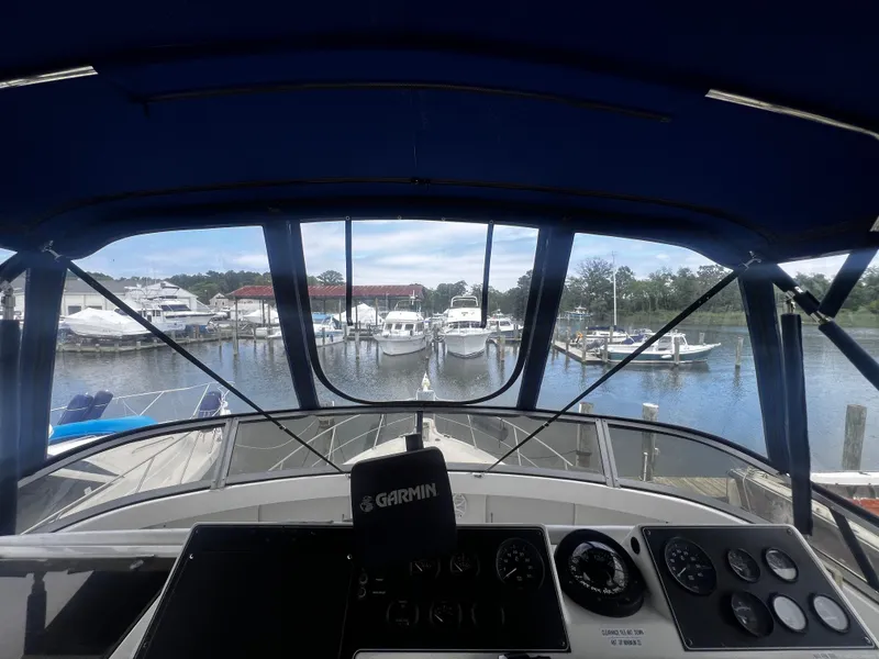 Slide: The Image of View from the helm of a 1993 Carver 350 Aft Cabin yacht docked at a marina. - 16