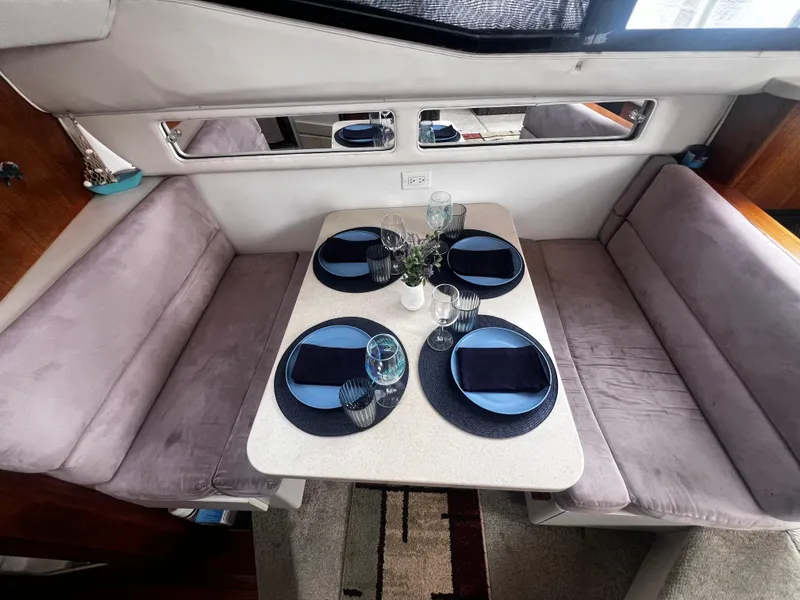 Slide: The Image of Dining area in a 1993 Carver 350 Aft Cabin yacht with a set table. - 23