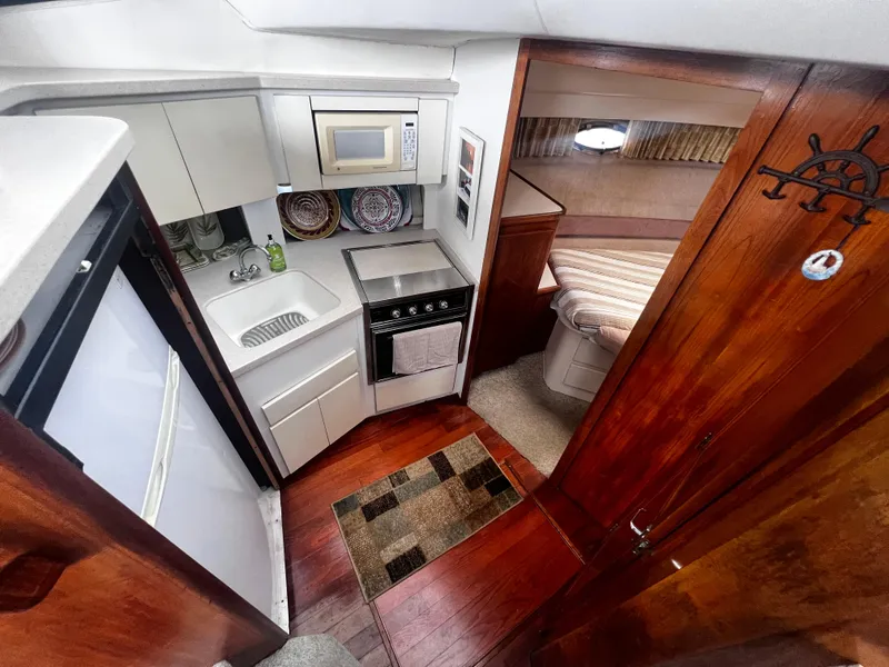 Slide: The Image of 1993 Carver 350 Aft Cabin kitchen and bedroom interior with modern amenities. - 26