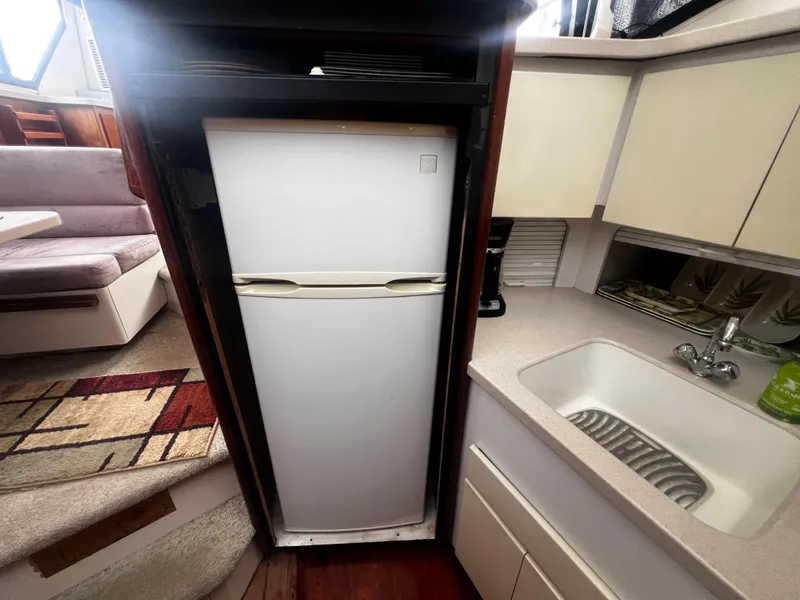 Slide: The Image of 1993 Carver 350 Aft Cabin kitchen with fridge, sink, and dining area. - 28