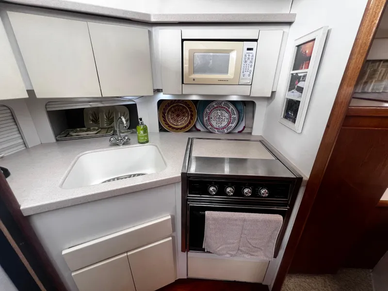 Slide: The Image of Compact kitchen in a 1993 Carver 350 Aft Cabin yacht with sink, stove, and microwave. - 30