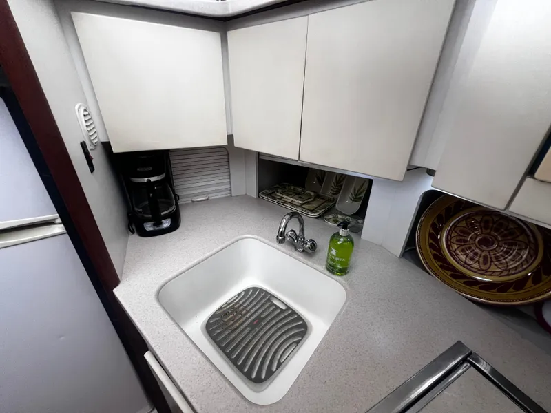 Slide: The Image of 1993 Carver 350 Aft Cabin kitchen with sink, coffee maker, and dishware. - 33