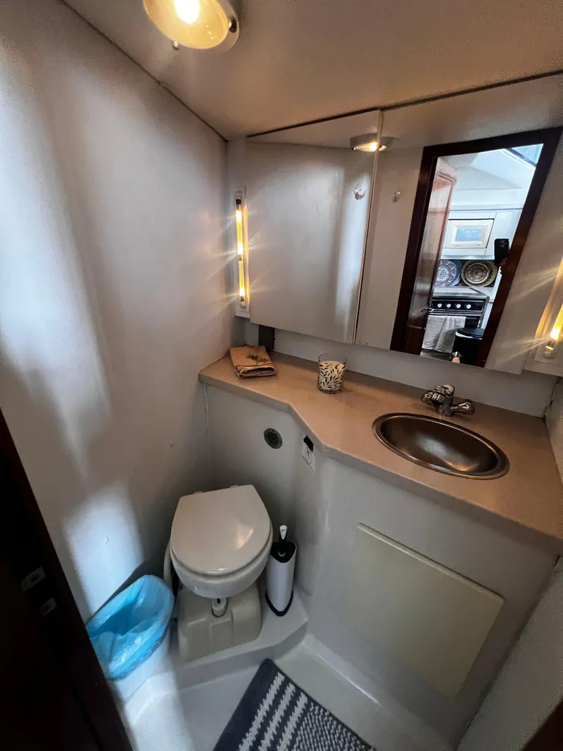 Slide: The Image of 1993 Carver 350 Aft Cabin bathroom with toilet, sink, and mirror. - 36