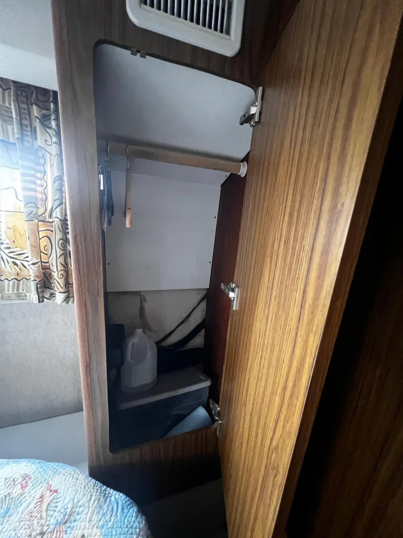 Slide: The Image of Open closet in 1993 Carver 350 Aft Cabin boat with wooden interior. - 47