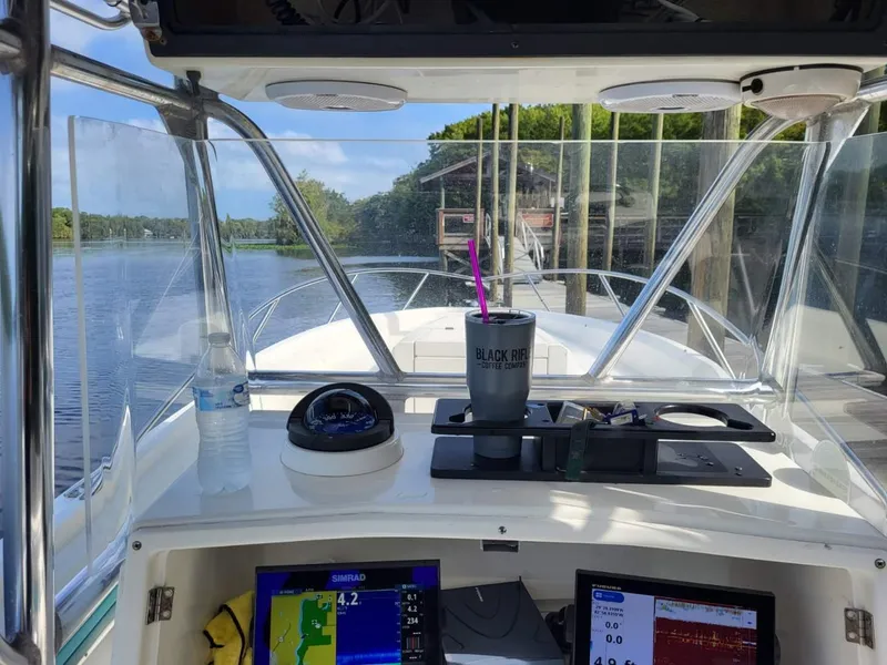 Slide: The Image of 1994 Fountain 31 CC boat dashboard with navigation equipment and water bottle. - 4