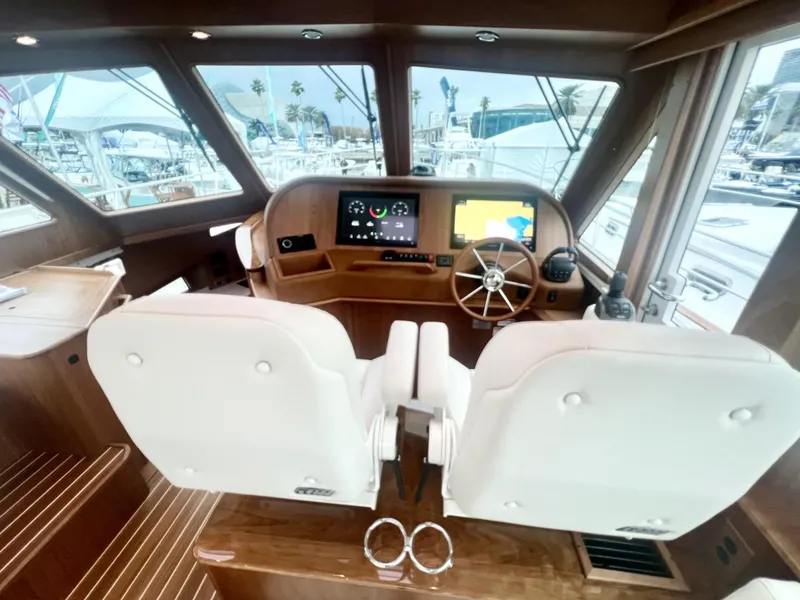 Slide: The Image of Interior of 2025 Sabre 48 Salon Express yacht with modern helm and dual white seats. - 13