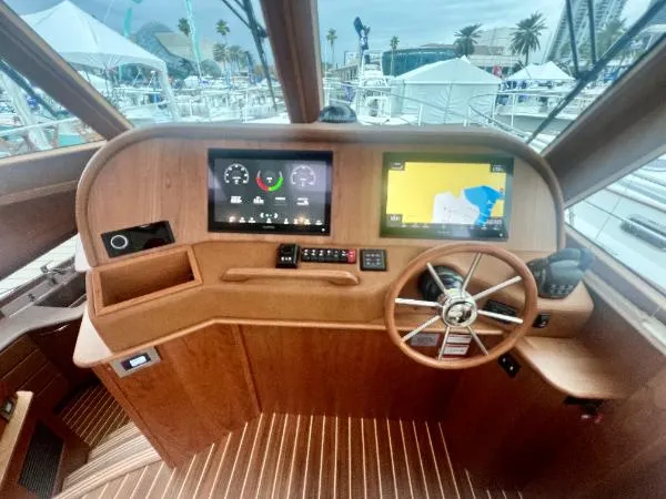 Slide: The Image of Helm of 2025 Sabre 48 Salon Express with modern navigation displays and wooden finish. - 14