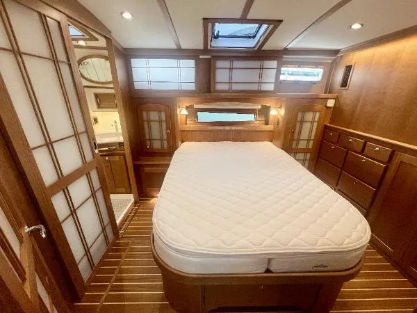 Slide: The Image of 2025 Sabre 48 Salon Express bedroom with wooden interior and skylight. - 16