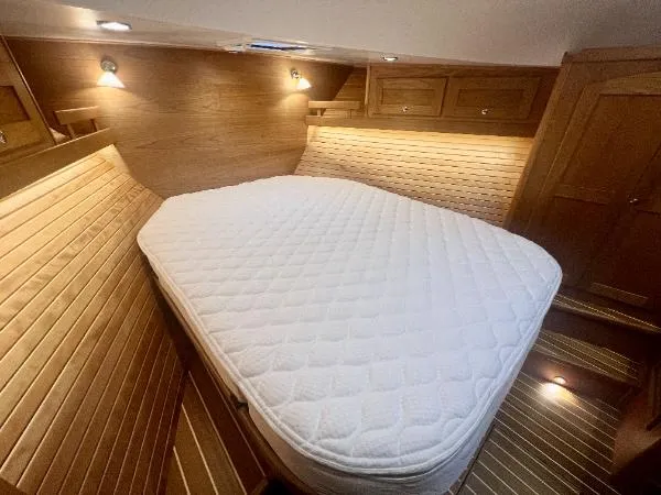 Slide: The Image of 2025 Sabre 48 Salon Express cabin with cozy bed and wooden interior. - 20