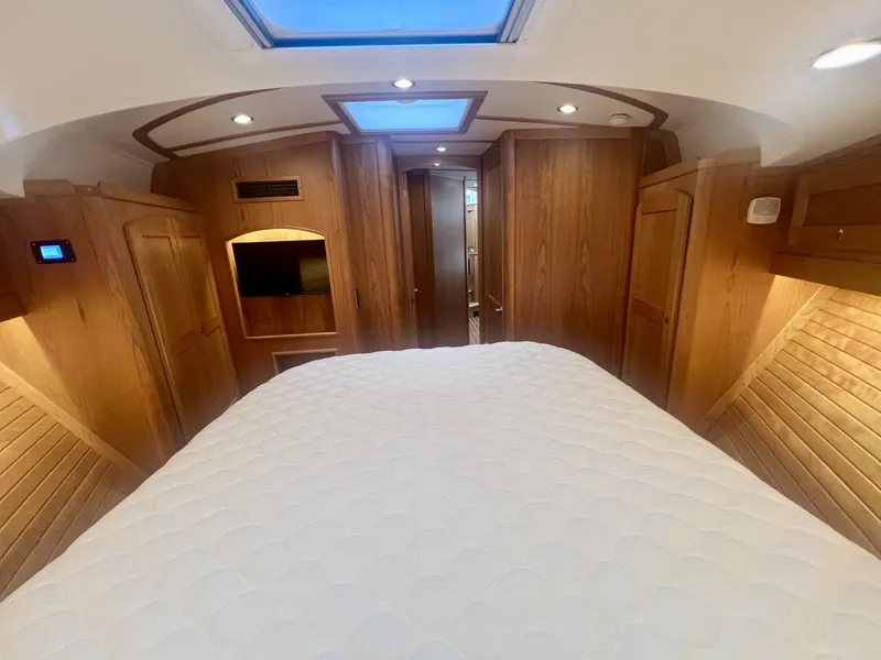 Slide: The Image of Interior of 2025 Sabre 48 Salon Express, featuring a luxurious wood-finished cabin with a skylight. - 22