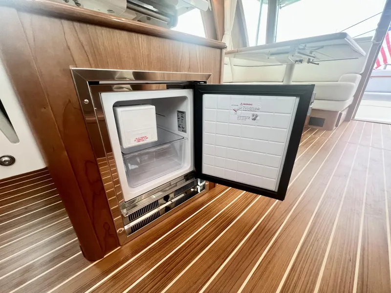 Slide: The Image of Open mini fridge on 2025 Sabre 48 Salon Express yacht with wooden flooring. - 23
