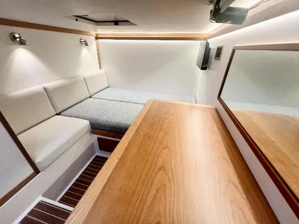 Slide: The Image of 2025 Sabre 48 Salon Express interior with modern seating and wooden table. - 25