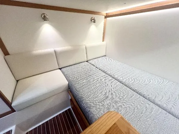 Slide: The Image of 2025 Sabre 48 Salon Express cabin with modern bedding and ambient lighting. - 26