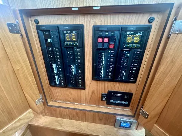 Slide: The Image of Electrical panel inside 2025 Sabre 48 Salon Express yacht, featuring circuit breakers and control switches. - 29