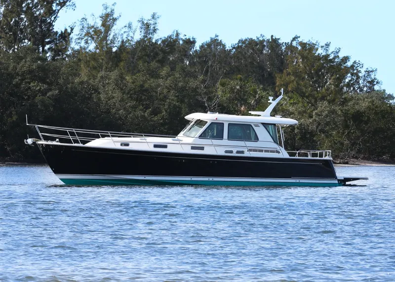 Slide: The Image of 2025 Sabre 48 Salon Express yacht cruising on a calm lake. - 3