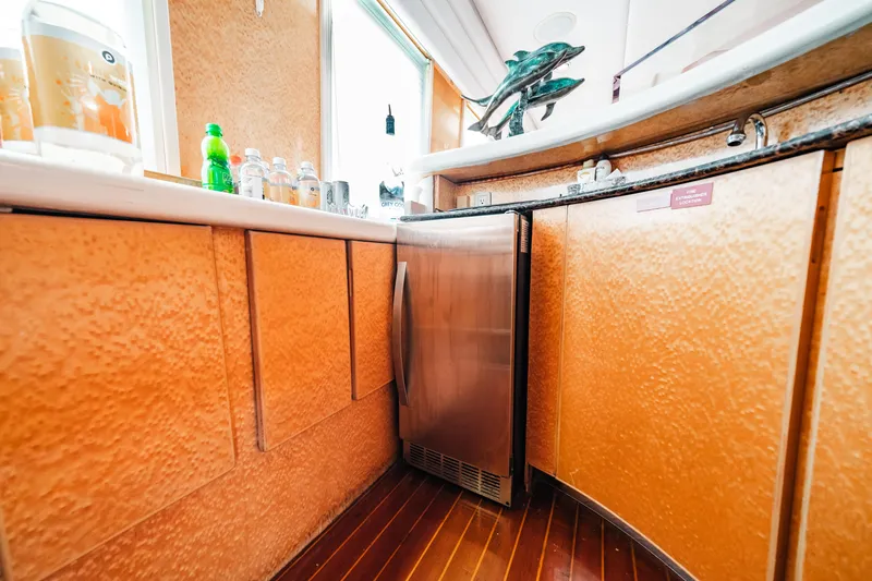 Slide: The Image of Galley kitchen in a 1992 Monte Fino 94 Motor Yacht with wooden cabinets and stainless steel fridge. - 32