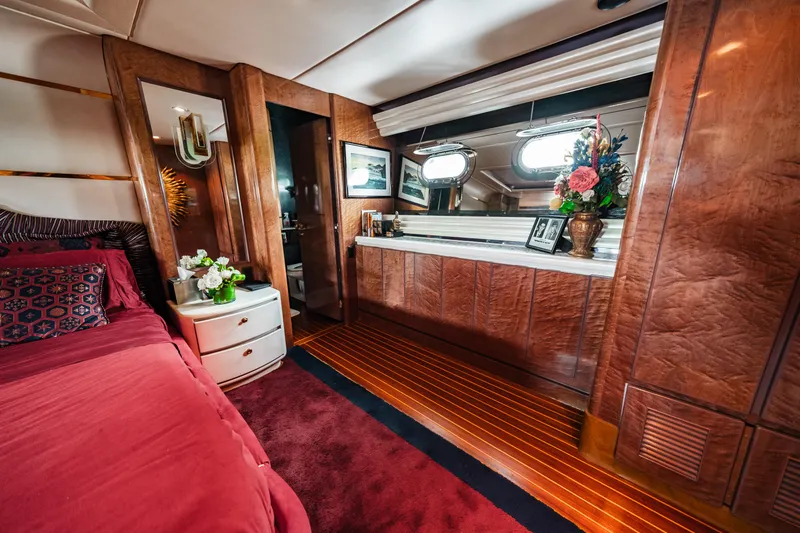 Slide: The Image of Luxurious bedroom interior of 1992 Monte Fino 94 Motor Yacht with wood paneling and red bedding. - 40
