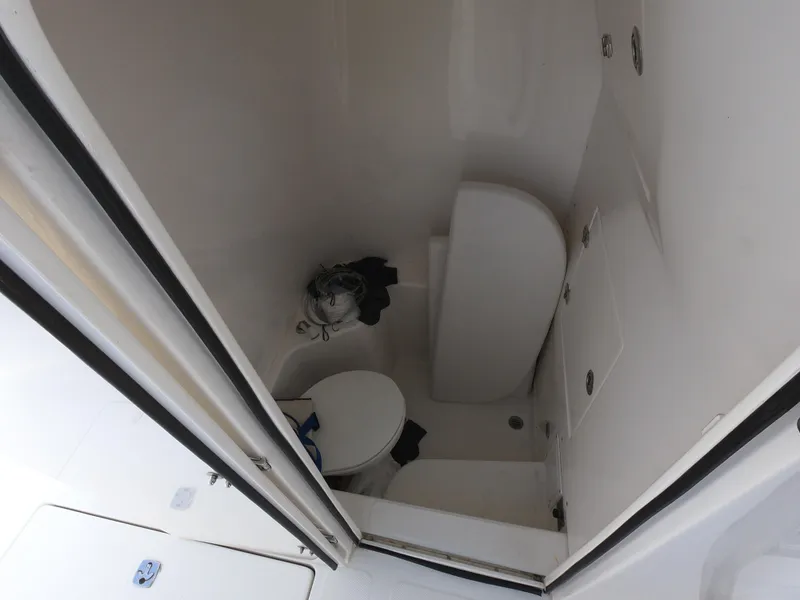 Slide: The Image of 2003 Venture 34 Open boat bathroom interior with toilet and storage compartments. - 14