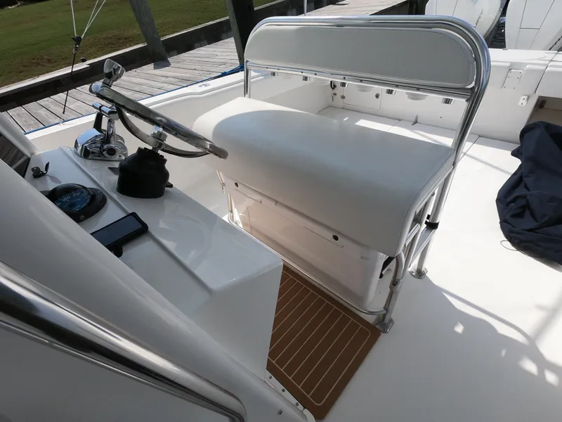 Slide: The Image of 2003 Venture 34 Open boat helm with white seating and steering wheel. - 15