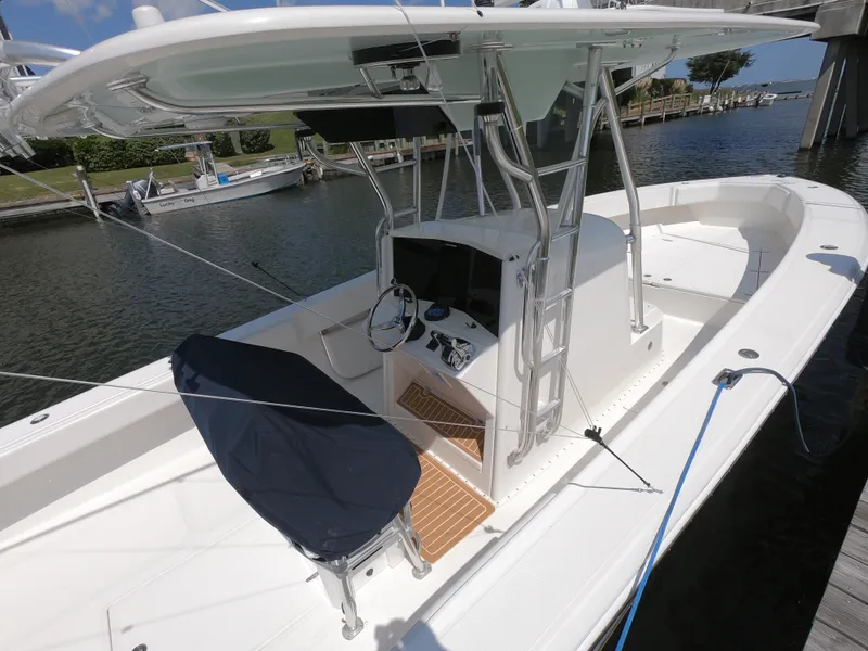 Slide: The Image of 2003 Venture 34 Open boat docked, featuring a central console and covered seating. - 3