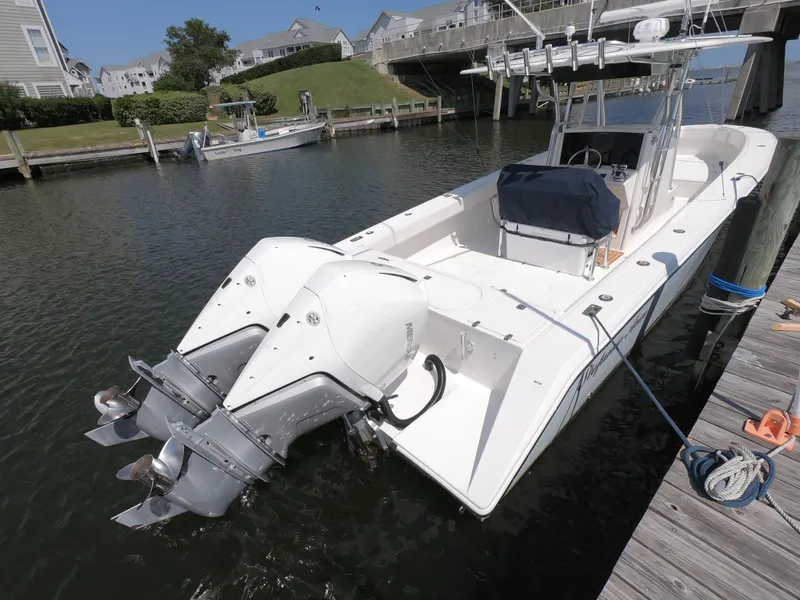 Slide: The Image of 2003 Venture 34 Open boat docked, featuring dual outboard motors. - 5