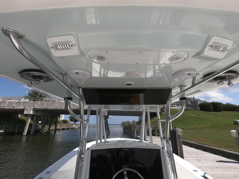 Slide: The Image of 2003 Venture 34 Open boat, view of helm and T-top structure by a dock. - 7