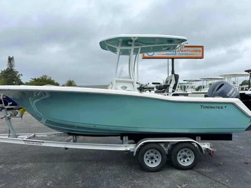 Slide: The Image of 2023 Tidewater 220 CC Adventure boat on a trailer at a marine center. - 1