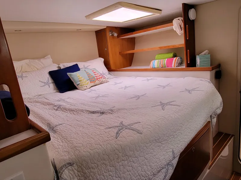 Slide: The Image of Cozy bedroom in 2009 Fusion 40 yacht with starfish-themed bedding and wooden shelves. - 36