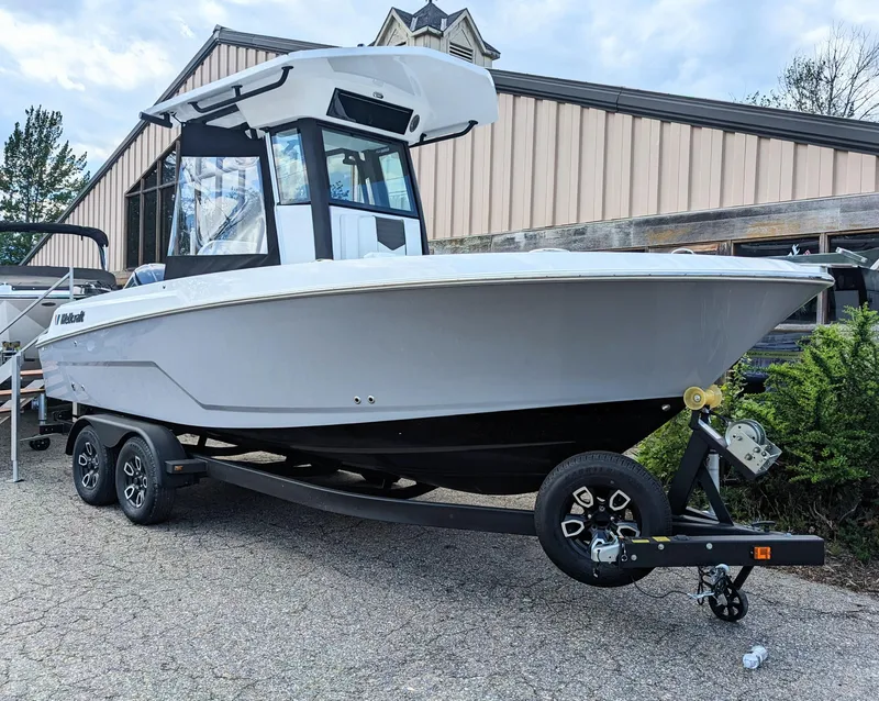 Slide: The Image of 2024 Wellcraft 223 Fisherman boat on a trailer outside a building. - 0