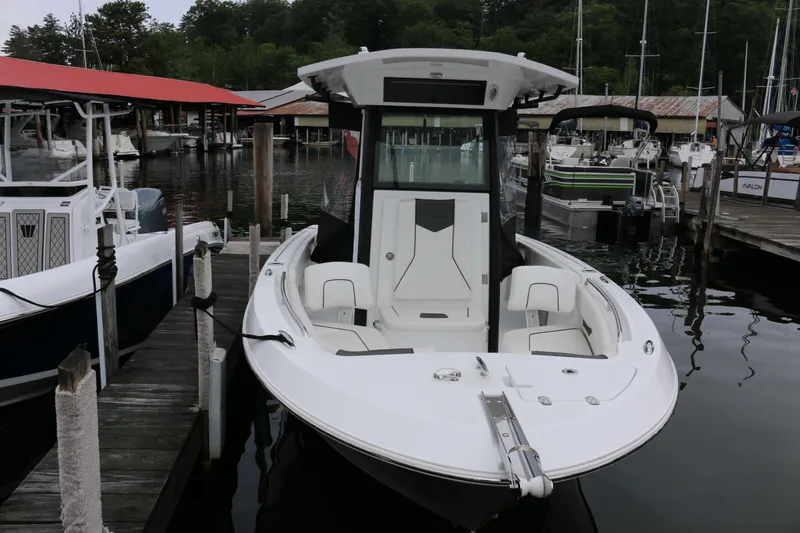 Slide: The Image of 2024 Wellcraft 223 Fisherman boat docked at marina, surrounded by other vessels. - 1