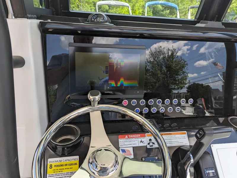 Slide: The Image of 2024 Wellcraft 223 Fisherman dashboard with steering wheel and navigation screen. - 10