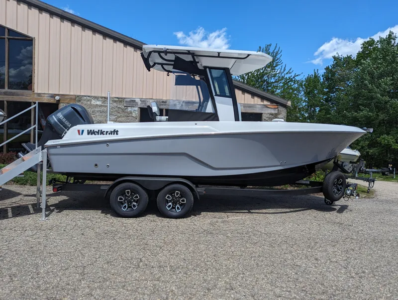 Slide: The Image of 2024 Wellcraft 223 Fisherman boat on a trailer, parked outdoors. - 2